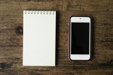 Boş sayfa defter ahşap masa akıllı telefon ile üstten görünüm görüntüsü