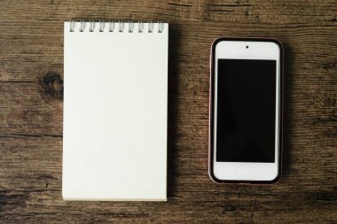 Boş sayfa defter ahşap masa akıllı telefon ile üstten görünüm görüntüsü