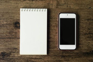 Boş sayfa defter ahşap masa akıllı telefon ile üstten görünüm görüntüsü