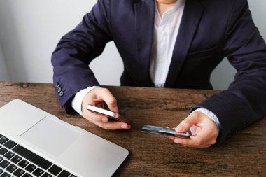 Kredi kartı tutan ve online alışveriş için akıllı telefon kullanarak online ödeme Mans eller