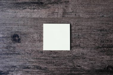 Ahşap masa boş bir yapışkan not kağıdına görüntüsünü üstten görünüm
