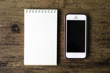 Boş sayfa defter ahşap masa akıllı telefon ile üstten görünüm görüntüsü
