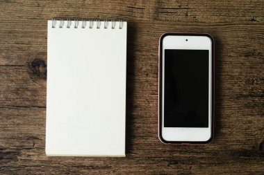 Boş sayfa defter ahşap masa akıllı telefon ile üstten görünüm görüntüsü