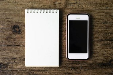 Boş sayfa defter ahşap masa akıllı telefon ile üstten görünüm görüntüsü