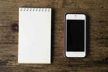 Boş sayfa defter ahşap masa akıllı telefon ile üstten görünüm görüntüsü