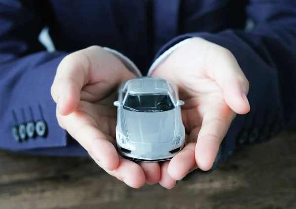 Miniature car model on hand, Auto dealership and rental concep
