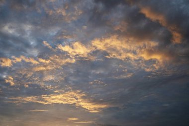 Mavi gökyüzünde dramatik bulutlu ve gün batımı