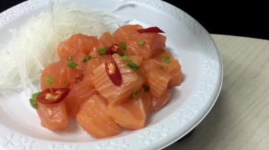 Beyaz çanak üzerinde baharatlı salata somon balığı