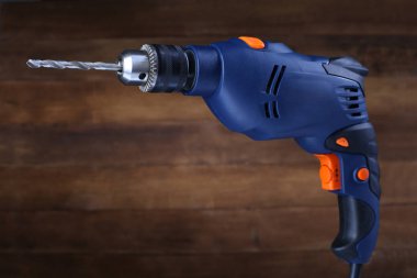 Ahşap arka plan üzerinde elektrikli matkap. Portre