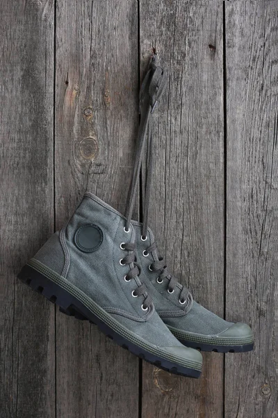 Ahşap Bir Duvarda Asılı Yeşil Askeri Spor Ayakkabı — Stok fotoğraf