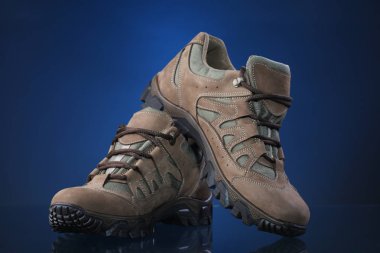 Mavi degrade arka plan üzerinde yürüyüş botları