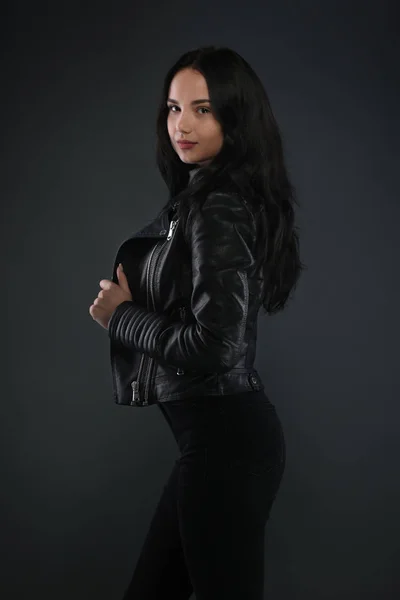 Kız koyu gri arka plan üzerinde siyah deri ceketli