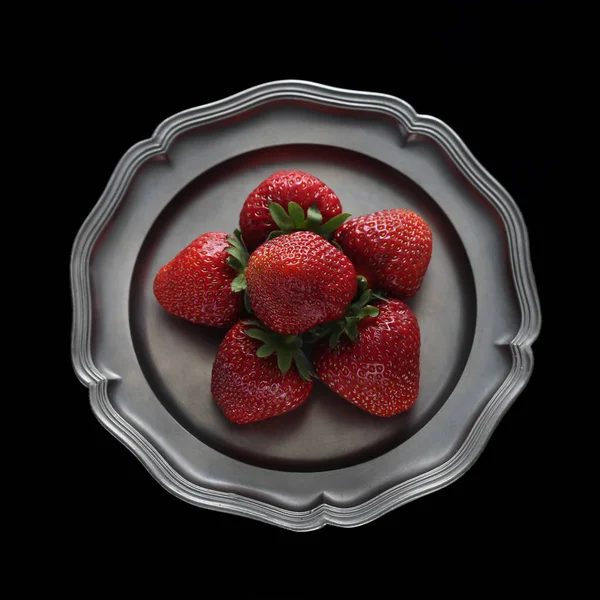 Strawberries on tin plate isolated on black background — Stock Photo, Image