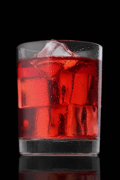 Roter Cocktail mit Eiswürfeln isoliert auf schwarz — Stockfoto