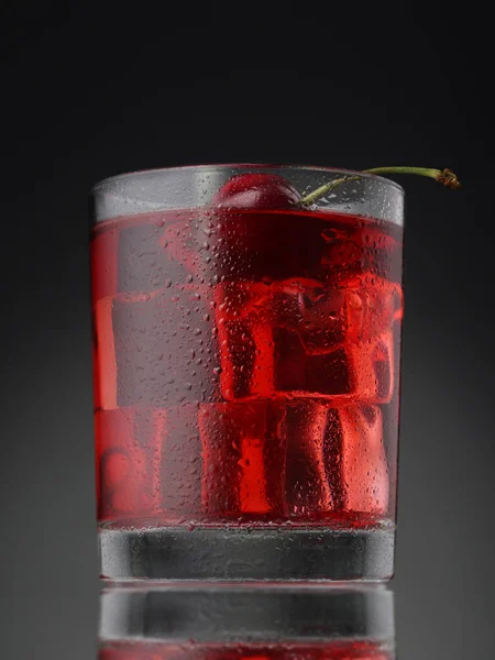 Coquetel vermelho com cubos de gelo no fundo gradiente — Fotografia de Stock