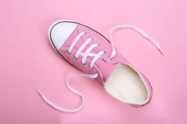 Pembe arka plan üzerinde pembe kadın spor ayakkabıları