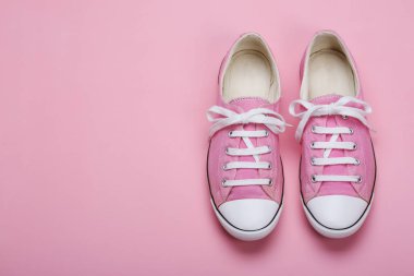 Pembe arka planda pembe kadın spor ayakkabı çifti