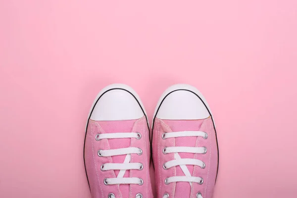 Par rosa kvinnliga sneakers på rosa bakgrund — Stockfoto