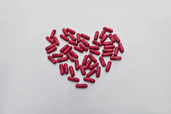 Hapların ve kapsüllerin kalbi beyaz arka planda izole edilmiş.