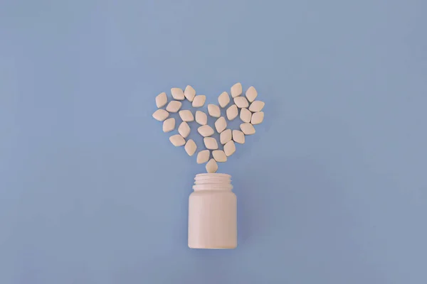 Comprimidos e cápsulas de medicamentos. Forma do coração e garrafa de comprimidos. Espaço de cópia para texto — Fotografia de Stock