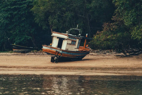kumlu bir plaj üzerinde ahşap balıkçı teknesi