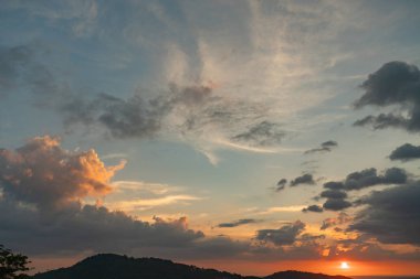 mavi bulutlu gökyüzü ve gün batımı renklerde güneş