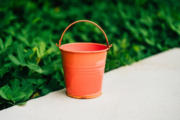 Coral watering buckets for plants in garden