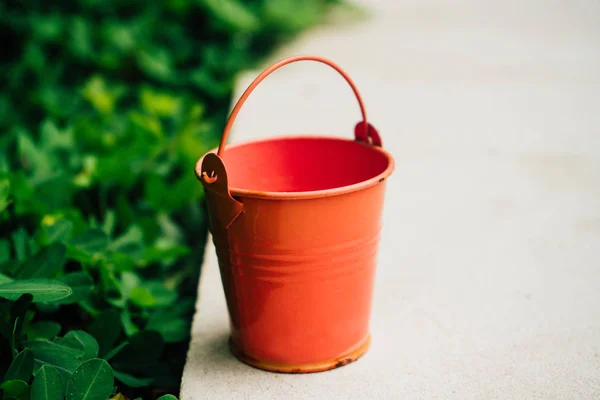 Coral watering buckets for plants in garden
