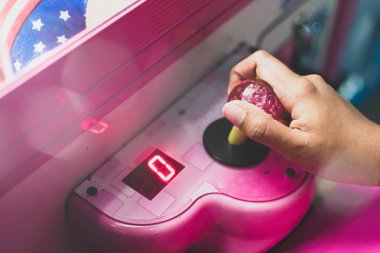 Seçici odak arcade oyunu oynarken oğlanın elini yukarıya kapatmak.