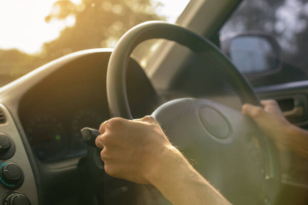 Закрыть азиатский мужчина рука вождения автомобиля утром в избирательном фокусе
.