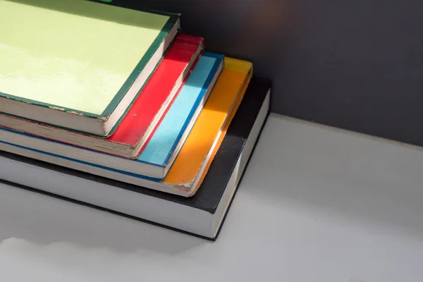 Close up books stacked on the table at the university library in selective focus.