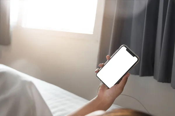 Asyalı kadının el sabah yatak boş ekran smartphone kullanarak.
