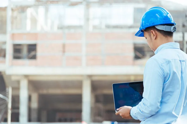 Engenheiro Com Capacete Segurança Azul Segurando Laptop Local Construção — Fotografia de Stock