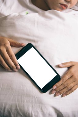Asyalı kadının el sabah yatak boş ekran smartphone kullanarak.