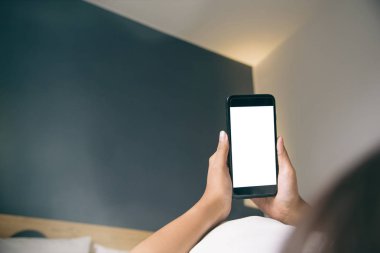 Asyalı kadının el sabah yatak boş ekran smartphone kullanarak.