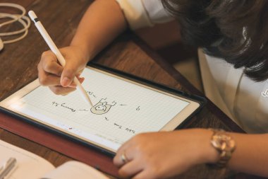 Genç Asyalı serbest grafik tasarımcı tablet seçici odak kahve dükkanında çalışan görünümünü kapat.  