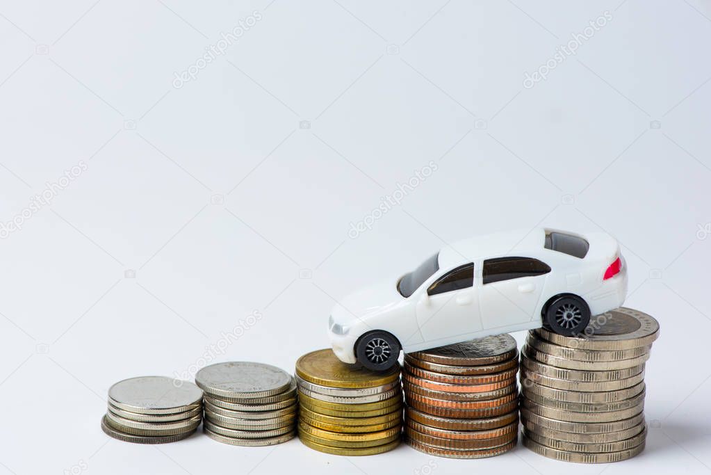 White car with stacked coins on white background