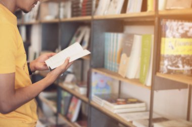 Selectiv kütüphanede bir kitap okuma Asyalı öğrenci yakın