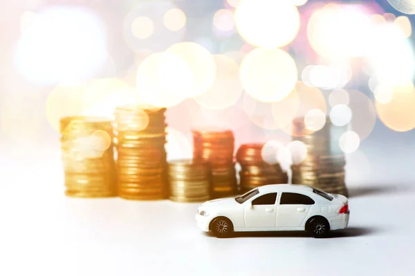 White car with stacked coins on white background in selective focus, Concept : car, money, financial, business.