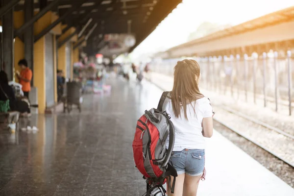 Rückansicht einer jungen asiatischen Touristin, die am Bahnhof auf ihren Zug wartet — Stockfoto