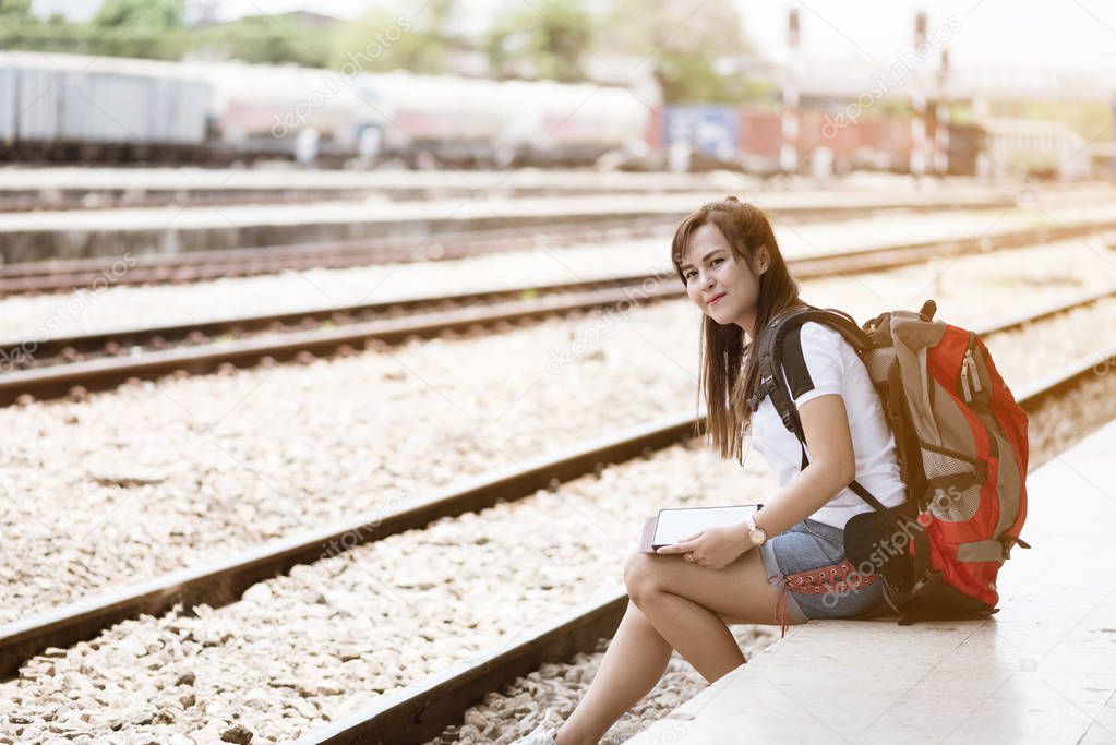 Asia woman traveller feeling happiness waiting for a train at tr