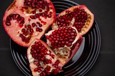 Parçalara ayrılmış taze el bombaları siyah bir masada duran bir tabakta duruyor..