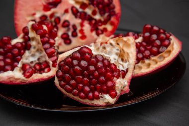 Parçalara ayrılmış taze el bombaları siyah bir masada duran bir tabakta duruyor..