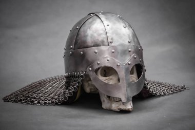 Gri arka planda, Viking kasklı bir kafatası.