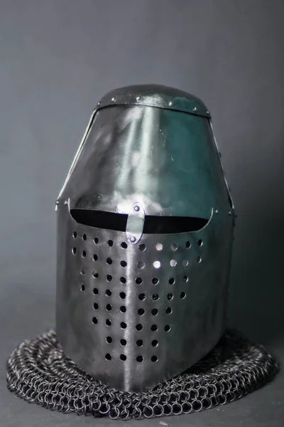 Knight\'s helmet and chainmail hood. Gray background. Topfhelm.