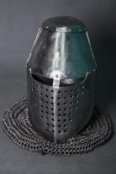 Knight's helmet and chainmail hood. Gray background. Topfhelm.