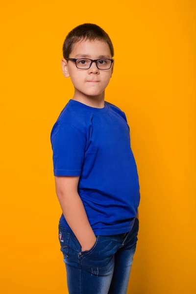 Portret Chłopca Okularach Niebieskiej Koszulce Stoi Żółtym Tle — Zdjęcie stockowe