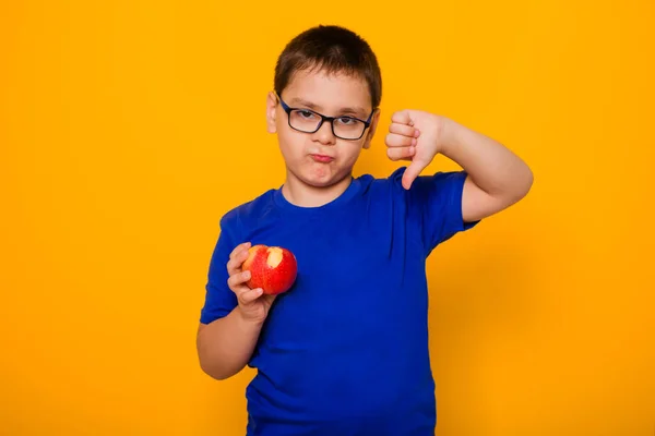 Retrato Menino Óculos Uma Camiseta Azul Fica Fundo Amarelo Segura — Fotografia de Stock