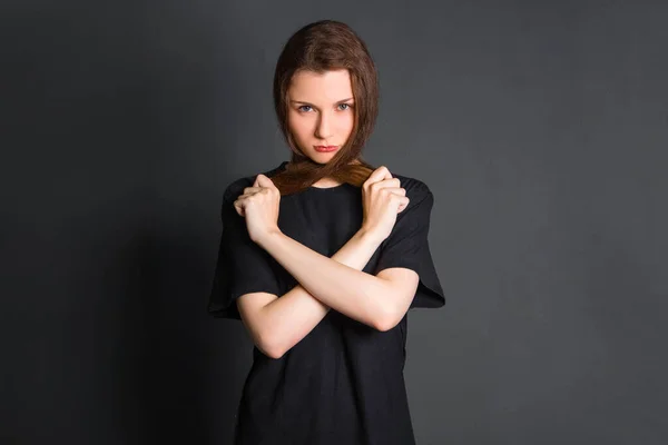 黒の服を着た美しい若い女性が髪を持っている スタジオの写真 灰色の背景に きれいな肌のモデル — ストック写真
