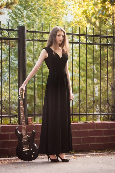 Mooie Jonge Vrouw Een Zwarte Jurk Met Een Gitaar Haar — Stockfoto